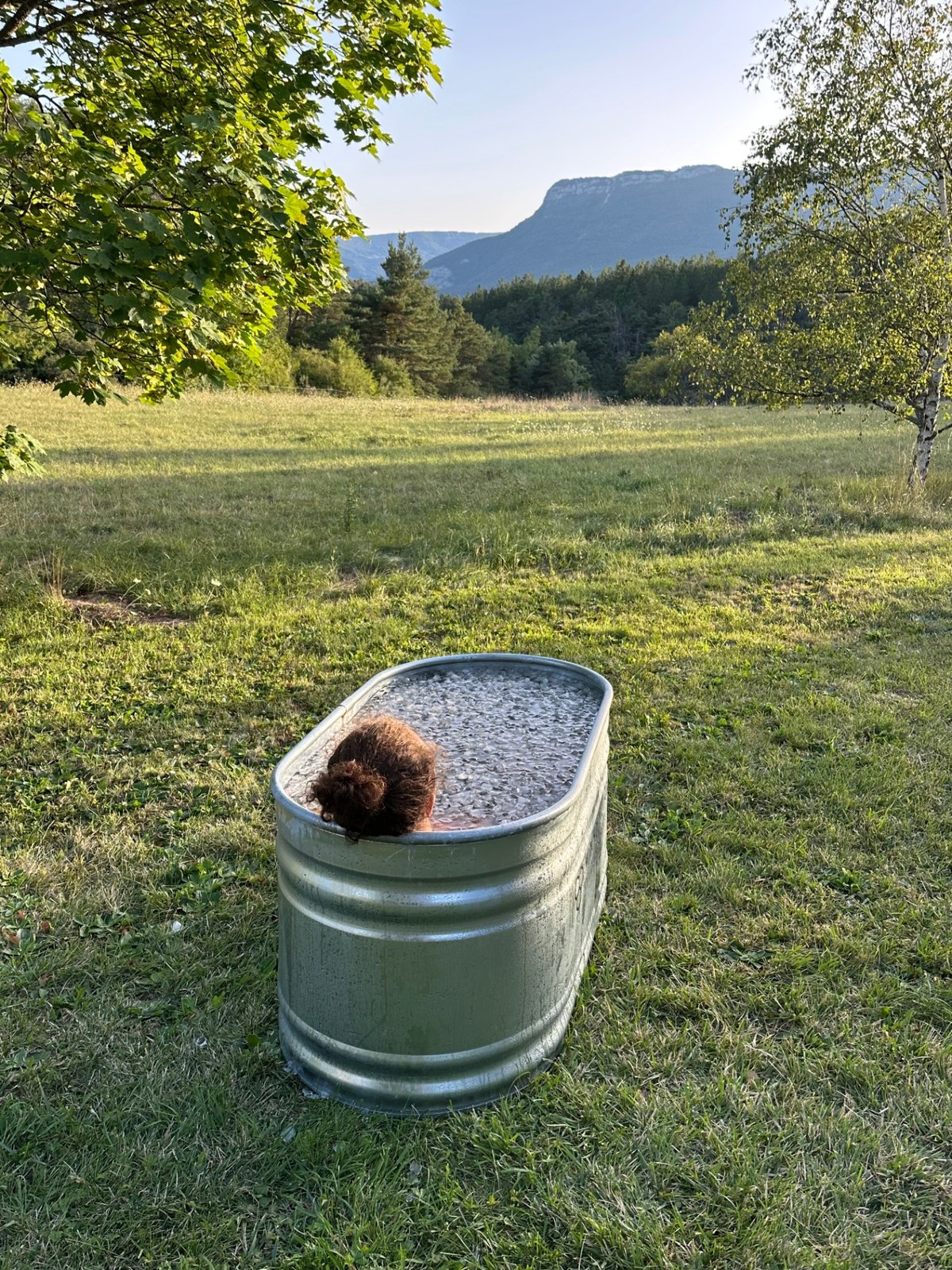 Bain glacé en pleine nature, face aux montagnes